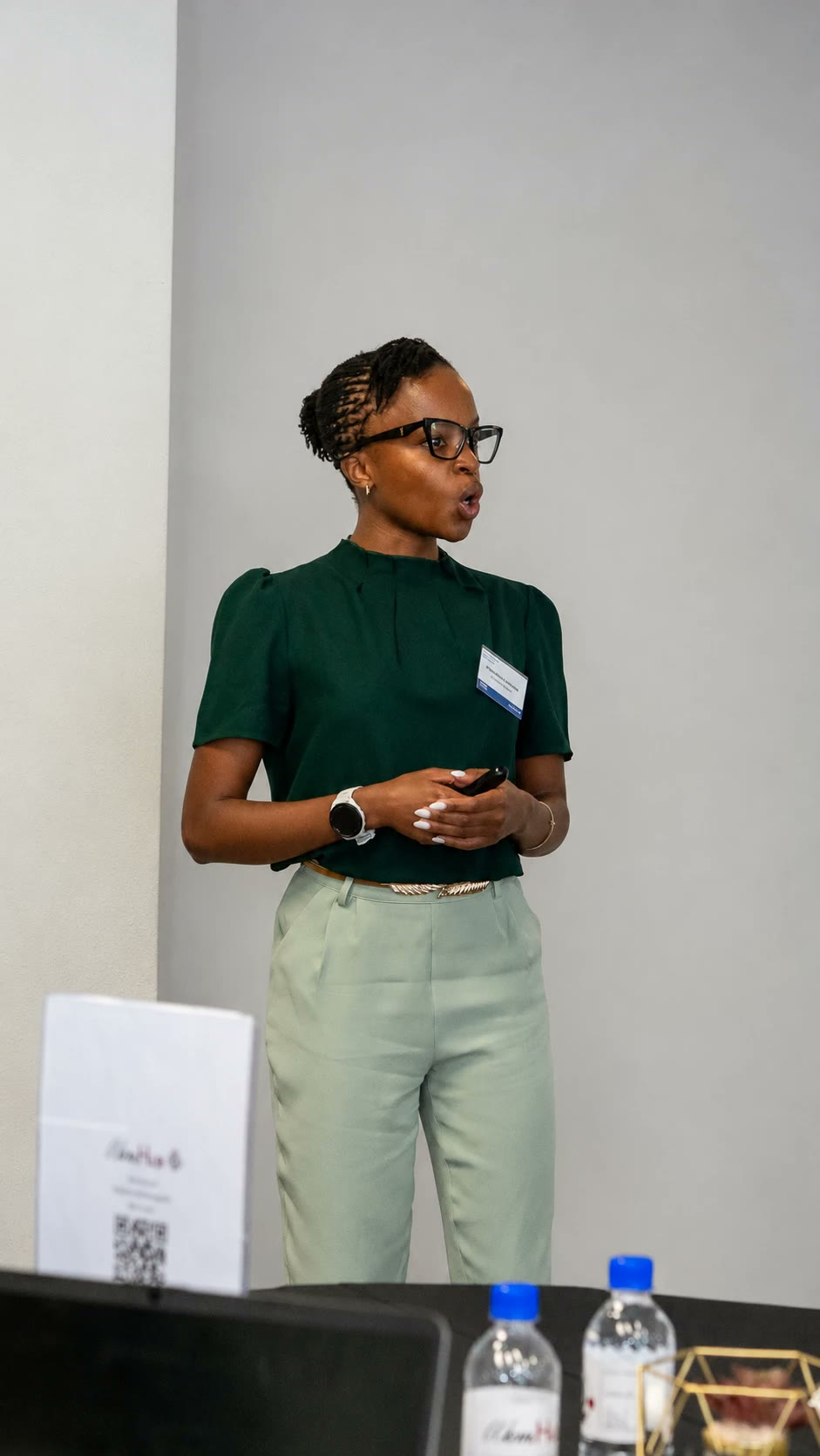 Nthabiseng Makhoba presenting, in a green blouse and sage trousers